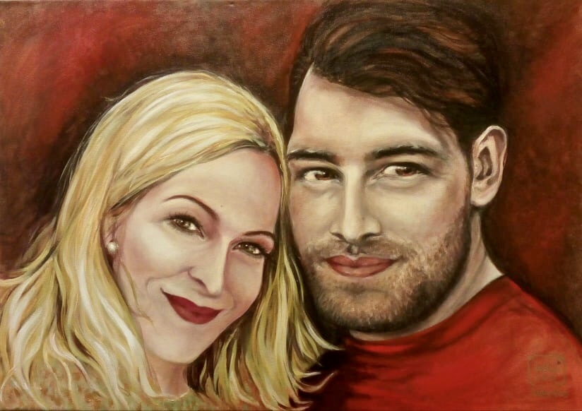 Portrét novomanželů na červeném pozadí.